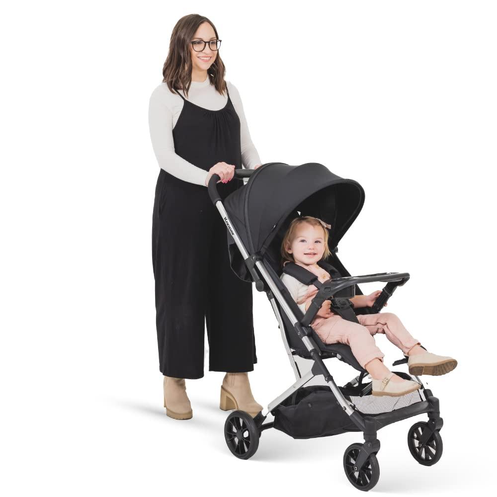 imageJoovy Kooper Lightweight Baby Stroller Featuring Removable SwingOpen Tray Big Wheels Reclining Seat with Footrest ExtraLarge Retractable Canopy and Compact Fold SandBlack